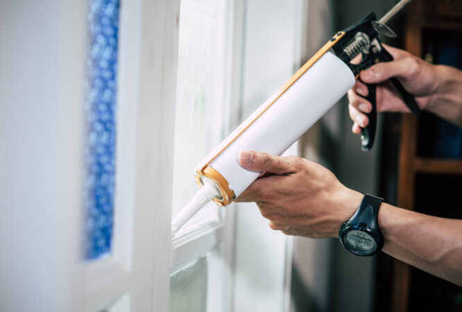 The carpenter holds the glue and attaches to the window. carpenter
