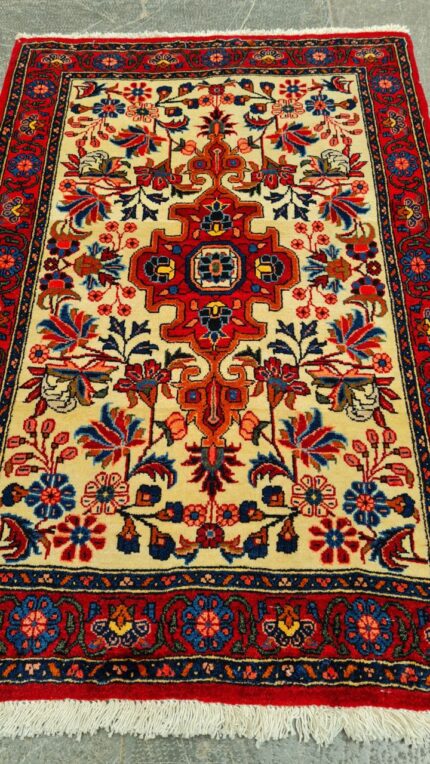 Hand-woven Persian rug from Kurdistan, Iran, featuring bold geometric patterns in deep red and navy blue.